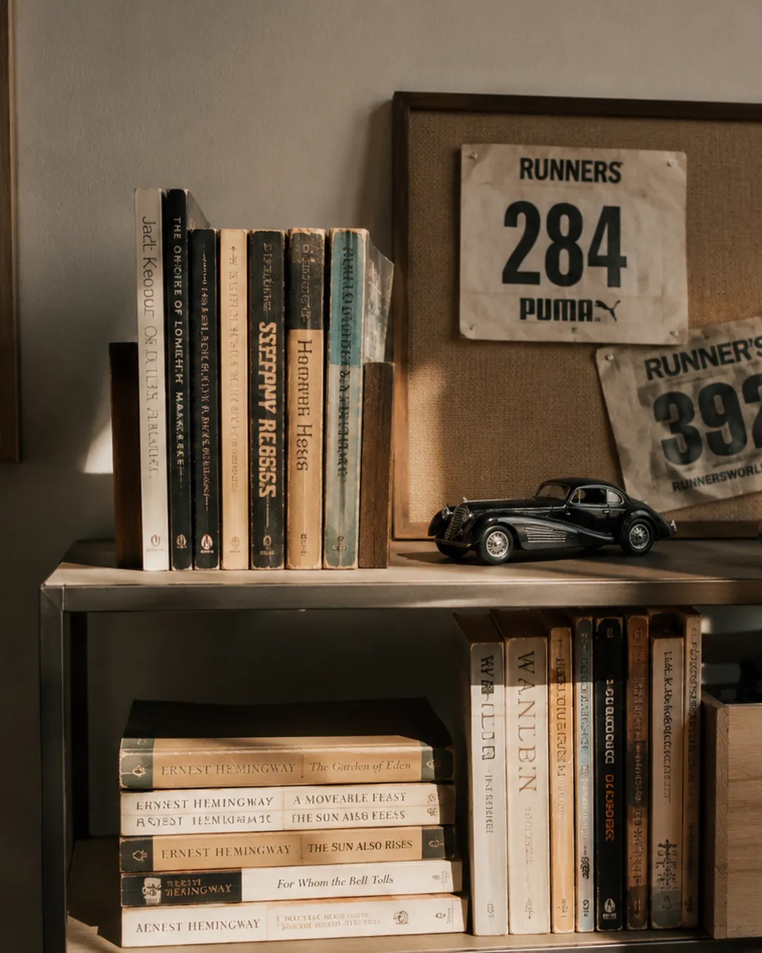 Open shelving styled with worn paperbacks, running race bibs, and a vintage model car